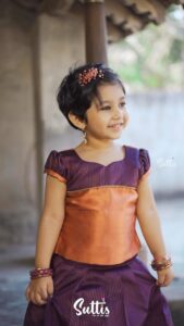 Alya Manasa Instagram - Aila looking super cute in this wonderful Pavadai Sattai from @suttis.kids 
.
Experience elegance at its best for your little girls with this nava purple semi silk pavadai and top! The beautiful knife pleated nava purple skirt with a copper border and elegant designs is paired with a puff sleeved top in purple and copper. The unique border on the top with exquisite zari details gives it a truly serene look!
.
Outfit: @suttis.kids 
Photography @p2click.in 
.
Follow them today and get your little one a special outfit today!!
.
#kids #kidswear #silk #traditional  #cotton #topandskirt #buttas #pavadai #set #traditional #style #elegance #pattupavadai #pattupavadailove #handloom #pattu #chennai #zari #silver #gold #silklove #suttis #suttiskids #cotton Loves her smile 😃 cutie pie #aila @suttis.kids outfit