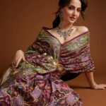 Elli AvrRam Instagram - Let’s fly together into the ‘Dream World’🦩✨ What say? Presenting @fablookmagazine new year’s special edition. Wearing this saree from @bandhanitraditionbyahasan and jewels from @jewelartic Editor & Founder @milliarora7777 @ankkit.chadha2222 Styled by @milliarora7777 @mitushigupta Mua @omkarvardam Hair @Swapnil_makeupnhair Belt @deebaco_official Shot by @nikhilshenoyphoto Coordinated by @nadiiaamalik