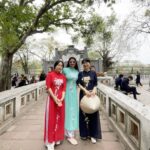 Archita Sahu Instagram - Many of you asked what I was wearing in last few posts . That’s ‘Ao dai’ . It’s the Vietnamese dress basically a silk tunic with straight pants . I got to know about it while talking to few locals who helped me with the shop address too to buy from. And here I am with few newly made local friends ❤️ NB : last pic shows my touristy mode 😂 #aodai #hoankiem #cafe #SabyArchita #archita #travel #road #rickshaw #bus #cafehoankiem #highlandcoffee