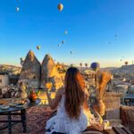 Kritika Sharma Instagram - The most favourite part of my turkey trip to do this 🤍 #gratitude Outfit @sainygargcouture Styled by @_vaishnavii.3011 Location @sultan_cave_suites #travel #whitedress #cappadocia #hotairballoon #photoshoot #terrace Sultan Cave Suites