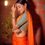 Kaavya Arivumani Instagram - Swipe and sing the song inayae 🍊🔶🧡 Shot by @studio212_photography Styled by @indu_ig Makeup @vishaa_hairandmakeup Drapist @anu_hairstylist_sareedrapist Wearing @varshamaran_official Earring @fineshinejewels #kaavya#kaavyaarivumani
