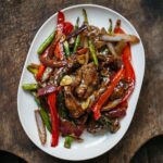 Adam Liaw Instagram - Tonight’s dinner. Beef, asparagus and capsicum with oyster sauce. Stir-frying is all about technique, but that's not to say that it's difficult. I've changed the way I stir-fry over the years to make things more efficient for home cooking. While restaurant cooking usually fries or oil-blanches the meat first, for home cooking I think it's better to cook the vegetables first and then remove them from the wok to fry the meat second, returning the vegetables to the meat later. This avoids the need to wash the wok if any meat sticks to the metal (which it usually shouldn't). This recipe fries the asparagus, capsicum and onion first, then the beef second, tossing everything together with simple seasonings of oyster sauce, soy sauce, wine and sugar. Recipe link in my profile.