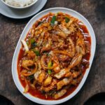 Adam Liaw Instagram - Tonight’s dinner. Butakimu. Japanese-style pork belly fried wok-fried with onions, gochujang and kimchi. The secret is a pat of butter tossed through at the end. One of the most important features I designed into the Everyday range I made for @noritakeaus was the ability for it to adapt to the multiple cuisines that we eat in Australia. The oval share plate was specifically designed to be the perfect share plate for the centre of a rectangular dining table (think vegetables dishes, shared steaks, or really any shareable food), and of course it’s the perfect size for a wok-fried dish. The shape of the plate catches sauces to create a uniform white border which makes the food stand out. We most often combine that with the small bowl and plate, which I designed to function as a rice bowl and underplate with chopsticks, but the kids usually eat from the medium bowl if they’re using a fork and spoon.