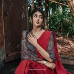 Drishya Raghunath Instagram - ग़ुलाब का फूल PHOTOGRAPHY : @jishnumurali_ MUA : @cosmoholic_by_amritha_sarath OUTFIT : @chithras_fashion_paradise RETOUCH : @abhishek__asokan ASSISTANT : pixel.monk._ LOCATION : @niramayamheritage #styling #red #saree #danielwellington #indowestern #drishya #drishyaraghunath