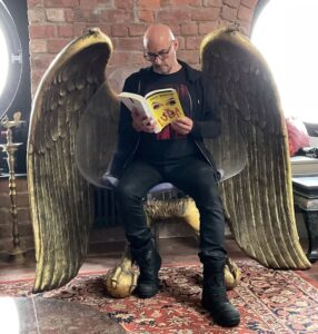 Grant Morrison Instagram - Angel or Devil…? Another exclusive #LUDA reading up now on Substack! With details of upcoming events in the US in September. #LUDA is coming, 6th Sept. Pre-order now, LINK IN BIO. #reading #video #skinparts #substack #xanaduum #newrelease #magic #pantomime #grantmorrison #glamour