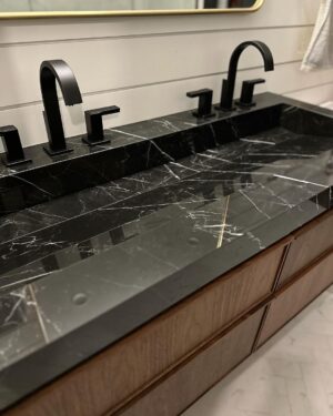John Colaneri Instagram - New sink designed, installed, and ready to use! The first sink I designed at our home had some design issues. Live and learn! This new sink by @faithfulcountertops is absolutely fire 🔥 ! Changed it up to a black porcelain that looks like marble but without the maintenance.  Thoughts on the design and how do you think we access the drain. 

#design #designinspiration #designgoals #surfacedesign #porcelain

Faucets by @brizofaucet