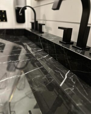 John Colaneri Instagram - New sink designed, installed, and ready to use! The first sink I designed at our home had some design issues. Live and learn! This new sink by @faithfulcountertops is absolutely fire 🔥 ! Changed it up to a black porcelain that looks like marble but without the maintenance.  Thoughts on the design and how do you think we access the drain. 

#design #designinspiration #designgoals #surfacedesign #porcelain

Faucets by @brizofaucet