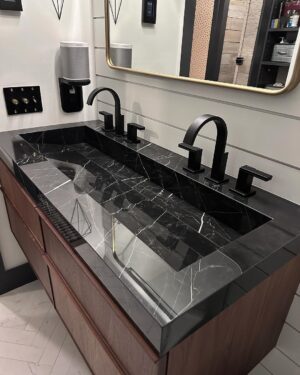 John Colaneri Instagram - New sink designed, installed, and ready to use! The first sink I designed at our home had some design issues. Live and learn! This new sink by @faithfulcountertops is absolutely fire 🔥 ! Changed it up to a black porcelain that looks like marble but without the maintenance.  Thoughts on the design and how do you think we access the drain. 

#design #designinspiration #designgoals #surfacedesign #porcelain

Faucets by @brizofaucet