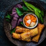 Kamila Rundusová Instagram - NEM RÁN. Kdysi dávno jsem se je učila ve vietnamské restauraci v městečku Danang, kde jsem válela stovky smažených závitků denně. Vedle mě stála vietnamská tetka, která mě sekýrovala za každý nepovedený, který jsem potom snědla já. A že jich bylo. Dneska jsem měla jedny k obědu. A byly pěkně suchý😅 Takže až dojedu domů, udělám je. Šťavnatý. Podle tohoto receptu přímo z restaurace, kde jsem pracovala. Najdete společně s mnoha dalšími asijskými recepty v mojí Nejbarevnější kuchařce, která je nyní za zvýhodněnou cenu na: WWW.CHEFKAMU.CZ Suroviny: 500 g mletého vepřového masa nebo tofu 100 g uvařených skleněných nudlí hrst sušeného jidášova ucha 100 g klíčků mungo fazole 1 cibule 3 jarní cibulky 2 mrkve 1 hrst stonků koriandru 2 vejce 30 listů rýžového papíru sůl a mletý pepř rostlinný olej na smažení k namáčení omáčka nuoc cham (najdete v knize) Postup: 1. Cibuli, jarní cibulku, stonky koriandru a česnek pokrájíme nadrobno. Mrkve nakrájíme škrabkou julienne na cca 4 cm dlouhé proužky. 2. Jidášovo ucho necháme ve vlažné vodě cca 15 minut nabobtnat, poté několikrát propláchneme vodou, dáme okapat a nakrájíme na tenké proužky. 3. Mungo klíčky propláchneme vodou a zbavíme zelených slupek. 4. V misce smícháme mleté maso s připravenou zeleninou a stonky koriandru, osolíme a opepříme. Přidáme jidášovo ucho, na kratší kusy pokrájené uvařené nudle, klíčky a necháme směs 5 minut odpočívat. Pak přidáme vajíčka a pečlivě zamícháme. ⬇️Jak na balení závitků najdete v komentáři⬇️ Ho Chi Minh City - Saigon, Vietnam