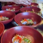 Kamila Rundusová Instagram - Děcka, já su tak šťastná. Nová stáž v michelinské restauraci @blackitch_artisan_kitchen v thajském horském městečku Chiang Mai je jiná než ty předešlé. Už od prvotní komunikace, kdy mi psali, jak se na mě těší, jsem tušila, že to bude boží. Hned po příchodu na mě pohoda a skvělá energie, a mě okamžitě napadlo, že to je jak u nás. Když mi řekli, ať se jdu domů převléknout, že mě zvou na 12-ti chodovou večeři, byla jsem dojatá. Asi u pátýho chodu se mi vehnaly slzy do očí. Každý chod ve mě probudil silný emoce, mají to tak moc dobrý a jedinečný. Explozivní a přitom jemný. Nedá se to popsat. Nic takovýho jsem předtím nejedla. A to, že jídla u stolu prezentuje sám šéfkuchař, to je nejvíc… Je cítit, jak moc jsou šéfkuchař Black a jeho žena Beer (jo, jakože Black Beer) velcí srdcaři. Kromě toho, že sbíraj suroviny v lese, všechno nakládaj a fermentujou, dělají si vlastní saké, švestkový víno, gin, vaří si pivo…. A hlavně se pořád smějou, pošťuchujou, dělaj si srandičky. Když jsem u servisu správně položila bylinku na jídlo, se zcela vážnou tváří mě plácali po ramenou a opakovali “well done, chef” a to je joke, který se opakuje imrvére, i když oloupu jen bramboru:) No, najednou se necítím sama. Cítím se fakt jak DOMA. Jak mezi svejma. Pocity euforie. GOLD! DĚKUJU!!!