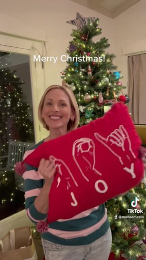Marlee Matlin Instagram - #merrychristmas #asl #signlanguage #happyholidays

Image description : Marlee Matlin signs “Merry Christmas” in American Sign Language, then pulls out a red pillow with the word JOY spelled out in ASL