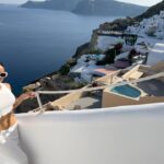 Natalie Negrotti Instagram - First time in Oia Santorini and I’m blown away by it’s beauty. My feet got so swollen I had to wear my pink shower chanclas to sight see before I bought matching Greek made sandals with my prima since my sneakers didn’t fit me! 😂 we rented a convertible red Fiat 🚗 and drove around exploring Santorini, Greece Oia, Santorini