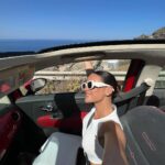 Natalie Negrotti Instagram - First time in Oia Santorini and I’m blown away by it’s beauty. My feet got so swollen I had to wear my pink shower chanclas to sight see before I bought matching Greek made sandals with my prima since my sneakers didn’t fit me! 😂 we rented a convertible red Fiat 🚗 and drove around exploring Santorini, Greece Oia, Santorini