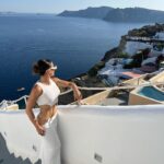 Natalie Negrotti Instagram - First time in Oia Santorini and I’m blown away by it’s beauty. My feet got so swollen I had to wear my pink shower chanclas to sight see before I bought matching Greek made sandals with my prima since my sneakers didn’t fit me! 😂 we rented a convertible red Fiat 🚗 and drove around exploring Santorini, Greece Oia, Santorini