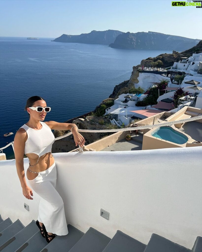 Natalie Negrotti Instagram - First time in Oia Santorini and I’m blown away by it’s beauty. My feet got so swollen I had to wear my pink shower chanclas to sight see before I bought matching Greek made sandals with my prima since my sneakers didn’t fit me! 😂 we rented a convertible red Fiat 🚗 and drove around exploring Santorini, Greece Oia, Santorini
