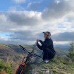 Rachel Atherton Instagram - Solo Adventures 🥰 but AM I A GENIUS ?! Have I discovered something new or does anyone else do this with their mid ride redbull?!! 🤯👌👌 Honestly I couldn’t believe I’ve never put my redbull in here for the climb 😂 instead of spending the whole climb holding it between brake lever and grip 😂 Anyway, last week I was trying to pedal some distance & I set off with good intentions, but when I pedalled past the jumps…. I literally spent the whole time just lapping the middle section of the @oakleybike Icon Way jumps @dyfibikepark 😂 It was so good just carving jumps solo & taking in this view on the climb back up 😍😍