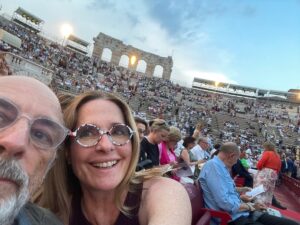 Sheila Kelley Instagram - Last summer we travelled through the magnificent country of Italy. This photo is from the outside opera house in Verona. In the middle of the opera, a torrential thunderstorm struck, and Richard and I were separated from each other for about an hour. It was chaos. People were running and screaming, in all directions, trying to get out of the rain and away from the lightning.
⠀⠀⠀⠀⠀⠀⠀⠀⠀
When we were finally able to get to each other I broke down in his arms with such relief. He is home. 
⠀⠀⠀⠀⠀⠀⠀⠀⠀
Love’s journey is an adventure, where challenges become the threads weaving a tapestry of connection. In the depth of love, we find the most rewarding chapters – building a life and a home together. 💖🏡 #LoveEndures #JourneyTogether