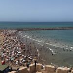 Vera Kolodzig Instagram – Saímos das ruínas de Volubilis já tarde e a chegada a Rabat foi já de noite. O grande desafio foi eu ver estrelinhas às cores a brilhar à minha frente por causa da minha falta de vista e lentes já cansadas. 
A capital de Marrocos é uma montra não muito representativa do resto do país e ainda assim encantadora! A vila nova distingue-se por avenidas de palmeiras alinhadas, a medina é de fácil circulação, a praia mesmo ali confere um aroma a maresia presente no ar, e o imponente Kasbah tem um ambiente sereno, tranquilo e limpinho (um kasbah é a cidadela das cidades árabes fortificadas). O turismo é pouco e maioritariamente local, mas na minha opinião vale a pena uma passagem por aqui para vaguear pelas avenidas largas e admirar as imponentes portas da cidade velha. Ainda nos atrevemos a um mergulho no mar, sendo claramente, as únicas duas europeias numa praia com centenas de pessoas. Para além disso ainda pudemos admirar o incrível trabalho de alguns artesãos que picam minuciosamente azulejos e criam os padrões tão tipicamente marroquinos.
Entretanto já nós fizemos à estrada outra vez, rumo a sul. Depois de uma paragem com temperaturas amenas, estamos preparadas para enfrentar o calor de Marraquexe.
.
.
.
#roadtrip #morocco #rabat #instatravel #travelwithfriends Rabat, Morocco