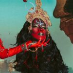 Vermelha Noir Instagram – 🩸 Chinnamasta 🩸
Es una diosa hindú que se representa desnuda auto-decapitada, normalmente en pie o sentada en una pareja divina copulando, sostiene su cabeza decapitada en una mano y una cimitarra en la otra. Tres chorros de sangre surgen de su cuello y son bebidos por la cabeza decapitada y dos asistentes.
Es la diosa de las contradicciones. Simboliza ambos aspectos de Devi: la que da y la que quita la vida. Es considerada tanto un símbolo de autocontrol sexual como una personificación de la energía sexual, dependiendo de la interpretación. Representa la muerte, la temporalidad y la destrucción así como la vida, la inmortalidad y la recreación. 

Para este trabajo en colaboración con @dankografia y @jesusteayude cuento con la presencia de ellos mismos como la pareja copulando y a mi hijo @bendeck_bendeck y @lvbnagaia cómo las entidades a los lados de la diosa.
.
Fotografía y dirección C
@dankografia @jesusteayude
Dress & heels: La presi y 
Makeup, headpiece & styling: Vermelha Noir
.
💄 PRODUCTOS 💄
⚪Base : Labial Rojo MAC Cruella
👁️ Ojos y contour : @jeffreestarcosmetics
⚫Delineador y cejas
@guerlain
🖤 Labios @naturalgirl
⬛ Enmarcado @bodypaintbykj
.
#fashion #drag #gay#art #makeup #lgbt #photograph #instagay #dragqueen #instadrag #dragrace#lgbtq #queen #dragmakeup #instagay #dragqueyensoyfinstagram #gayboy #dragqueenmakeup #fashion #fashiondesigner #makeupartist #style #art #localqueen #dragartist #red #secondhandclothing India : इंडिया