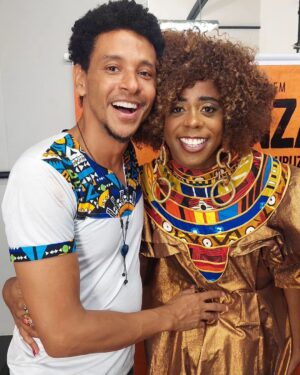 Aldri Anunciação Instagram - 🎈KOANZA: DO SENEGAL AO CURUZU🎈
* É incrível como o palco nos proporciona momentos únicos e nos permite aprender tanto com  artistas brilhantes.

*Eu tive a sorte de assistir a uma apresentação de Sulivã Bispo, um jovem ator que é uma verdadeiro explosão de talento no teatro brasileiro. Desde o momento em que ele pisou no palco, senti uma energia contagiante e uma presença magnética.

*Sulivã Bispo no espetáculo "Koanza - Do Senegal ao Curuzu" possui um domínio impressionante de sua performance e uma capacidade de transmitir emoções e nos divertir  de forma excepcional. Cada gesto, cada palavra dita por ele parecia estar impregnada de emoção genuína, envolvendo toda a plateia em uma reflexão bem humorada sobre as relações étnicas no Brasil. Impossível não se deixar levar por cada cena que ele criava no palco.

*E não são apenas suas habilidades como ator que são inspiradoras. Sulivã Bispo é um verdadeiro exemplo de dedicação e paixão pelo que faz. Ele se entrega por completo a cada personagem que interpreta e é visível o seu profissionalismo e comprometimento.

*Mas o que mais me marcou naquela noite  foi o quanto pude aprender com a sua personagem  Koanza. 

*Sulivã Bispo representa uma nova geração de artistas brasileiros que nos fazem acreditar no poder transformador da arte. Ele traz consigo histórias e experiências que muitas vezes estão à margem da sociedade, trazendo à tona questões importantes e nos fazendo repensar.

*Encontrar esse tipo de talento nos palcos brasileiros é um privilégio. Uma experiência que nos faz perceber o quanto a arte é capaz de  nos mobilizar. Sulivã Bispo é um exemplo marcante dessa explosão de talento que encontramos nos palcos e que nos ensina tanto.

*Diante de suas apresentações, sou convidado a refletir sobre a vida, sobre a sociedade em que vivemos e sobre o poder que cada um de nós tem de fazer a diferença e de construir nosso próprio caminho (Odu).

#TalentosBrasileiros #PalcosBrasileiros #ExperiênciasMarcantes #TeatroBrasileiro #teatronegro #sulivãbispo