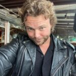 Ashton Irwin Instagram - 28, brushing up on my essential Buddhism , starting to wear the cowboy hat seriously, returning to the social security of a leather jacket & pressure washing at a pretty serious level now. And the last one with the thumbs up at LAX, is a guy who’s just hoping he didn’t get Covid in the airport, ciao!