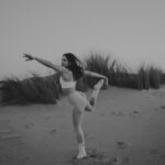Beatriz Costa Instagram - • 𝗖𝗢𝗥𝗣𝗨𝗦 𝗢𝗣𝗘𝗥𝗔𝗡𝗗𝗜𝗦 • What makes you move?//Qual é a in-tensão? Eu e o meu veículo dançante num momento de conexão e liberdade. Falar disso e não falar de amor é-me impossível. O movimento é sempre expressão de uma coisa que o antecede e não tem nome: porque vontade, motivação ou ímpeto são coisas posteriores a essa ainda. Há qualquer coisa que nos acontece quando decidimos que é por ali que vamos, que é aquela a direção, que é aquele passo e que é aquele o caminho.E depois o corpo segue, mas antes dele estamos a seguir essa coisa que nos faz mover. Essa atração irresistível que não sabemos como nem de onde nasce mas que quando nasce nunca mais nos larga. Deve chamar-se Amor. O movimento arbitrário pode ser lindíssimo por ser frívolo, inconsistente e inesperado,mas o movimento ponderado e intencional é a pegada que fica. Qual é a intenção por trás do movimento?Onde começa e onde a tua in-tensão,a tua tensão interna? Há um poema do José Régio que me mostraram quando era menina e que nunca mais me deixou. Chama-se “Cântico Negro”,e reza assim: "(...)Não, não vou por aí! Só vou por onde me levam meus próprios passos… Se ao que busco saber nenhum de vós responde, Por que me repetis: 'vem por aqui?'" Devia ter uns catorze anos quando o li, felizmente,porque me fez uma espécie de impressão profunda,uma tatuagem no meu subscinsciente de insubordinação e coragem.Isso é perigoso numa adolescente mas imperativo numa jovem adulta. O movimento.Decide-lo tu ou deixas que o façam isso por ti? E se não foste tu a escolher a direção,os passos que dás, ainda são teus? O ioga para mim é isto tudo e mais, porque juntamos a toda a equação o silêncio.E onde o silêncio está presente está também o segredo das coisas.E dançar com o segredo das coisas não nos torna mais sábios,mas torna-nos com certeza mais humanos e mais felizes. As fotografias foram tiradas pela @joanadartefotografou,que além de ter uma energia apaixonante ainda capta assim: com amor e subtileza. E depois a Isa,sempre a Isa.Ser mulher e estar rodeada de mulheres verdadeiramente incríveis empodera-me de uma forma que nunca vou conseguir exprimir com palavras. Mas tentarei sempre. Bom domingo!