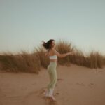 Beatriz Costa Instagram - • 𝗖𝗢𝗥𝗣𝗨𝗦 𝗢𝗣𝗘𝗥𝗔𝗡𝗗𝗜𝗦 • What makes you move?//Qual é a in-tensão? Eu e o meu veículo dançante num momento de conexão e liberdade. Falar disso e não falar de amor é-me impossível. O movimento é sempre expressão de uma coisa que o antecede e não tem nome: porque vontade, motivação ou ímpeto são coisas posteriores a essa ainda. Há qualquer coisa que nos acontece quando decidimos que é por ali que vamos, que é aquela a direção, que é aquele passo e que é aquele o caminho.E depois o corpo segue, mas antes dele estamos a seguir essa coisa que nos faz mover. Essa atração irresistível que não sabemos como nem de onde nasce mas que quando nasce nunca mais nos larga. Deve chamar-se Amor. O movimento arbitrário pode ser lindíssimo por ser frívolo, inconsistente e inesperado,mas o movimento ponderado e intencional é a pegada que fica. Qual é a intenção por trás do movimento?Onde começa e onde a tua in-tensão,a tua tensão interna? Há um poema do José Régio que me mostraram quando era menina e que nunca mais me deixou. Chama-se “Cântico Negro”,e reza assim: "(...)Não, não vou por aí! Só vou por onde me levam meus próprios passos… Se ao que busco saber nenhum de vós responde, Por que me repetis: 'vem por aqui?'" Devia ter uns catorze anos quando o li, felizmente,porque me fez uma espécie de impressão profunda,uma tatuagem no meu subscinsciente de insubordinação e coragem.Isso é perigoso numa adolescente mas imperativo numa jovem adulta. O movimento.Decide-lo tu ou deixas que o façam isso por ti? E se não foste tu a escolher a direção,os passos que dás, ainda são teus? O ioga para mim é isto tudo e mais, porque juntamos a toda a equação o silêncio.E onde o silêncio está presente está também o segredo das coisas.E dançar com o segredo das coisas não nos torna mais sábios,mas torna-nos com certeza mais humanos e mais felizes. As fotografias foram tiradas pela @joanadartefotografou,que além de ter uma energia apaixonante ainda capta assim: com amor e subtileza. E depois a Isa,sempre a Isa.Ser mulher e estar rodeada de mulheres verdadeiramente incríveis empodera-me de uma forma que nunca vou conseguir exprimir com palavras. Mas tentarei sempre. Bom domingo!