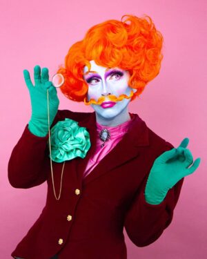 Daniel Wallace Instagram - Check out this gorgeous shot of me wearing a fancy new wig and tasche by the incredibly talented @florencias_wigs (I hear there will be a range available soon!) by @faketrashstudio 💗
Playing at being an effeminate gentleman and wearing my green carnation so everybody knows it 😂
#christmas #Greencarnation #Victorian #orange #moustache #Drag #Manchesterqueen #manchesterking