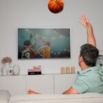 Diogo Beja Instagram - Quando era miúdo e jogava basket em Santarém, passávamos os intervalos a jogar e até nos corredores fazíamos uma espécie de "air basket" - driblávamos, lançávamos e até fazíamos bloqueios uns aos outros.. tudo sem bola. 🙈😁 Agora, com a chegada da segunda temporada de "Winning Time - The Rise of the Lakers Dynasty" isso voltou tudo! Imito o "gancho" do Kareem Abdul-Jabbar em todo o lado. É tão exagerado que até pedi à IA para colocar uma bola de basket a voar na nossa sala - a Mia ia adorar se isso acontecesse mesmo! 😁 Nestas férias, vou levar este meu "vício" comigo. Não o lançamento em gancho, mas a série. 😊 E para todo o lado, com a HBO Max. #HBOMax #WinningTime #HBOMaxPortugal #KareemAbdulJabbarWannaBe