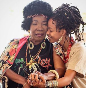 Donisha Rita Claire Prendergast Instagram - Grandma... You are the warmth of a Gentle Flame, the Cool of a Subtle Breeze, an Unquestionable Force of Light, Love, Leadership, Livity, and Laughter. A Visionary, a Teacher, a Survivor, a Souljah, a Goddess, a Queen. Your journey has been nothing short of Divinely crafted by the hands of the Most High. For you, there are not enough words to show how much you mean to me and millions of souls in the physical and spiritual manifest. 74 years on this Earth filled with lifetimes of experiences and HeArtwork. Keep on Keeping on.🔥💜🥳🦋🌏 Happy Earthday my Sweet Nana. We celebrate your everyday @officialritamarley. #TheRoot #TheFruit #IamBecauseYouAre #RastaWoman #FireStarter #LegacyKeeper #RitaMarley #74Strong
📸 @ahutchphoto