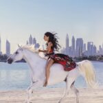 Kerri Kasem Instagram - Time with horses are some of my most beautiful memories. 🖤🤎🤍 This song is called “Zeit” which means, Time, in German. It’s from one of my most my favorite bands @rammsteinofficial! Dubai Team @portrait.stories - video @a3yan_stables - horsey TY @my_cavago for setting up this beautiful ride with the Dubai skyline! To ride almost anywhere in the world contact Cavago. @odalysmarino - Fashion @fashionweekstudioofficial TY @grissellehalime & @traveling_shooter_11b #Horse #Rammstein #reels #viral #trending