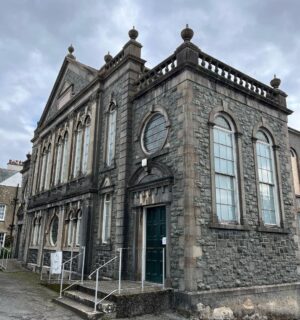 Kiri Pritchard-McLean Instagram - ⚠️ WARNING! SENTIMENTAL POST INCOMING ⚠️ 
This is where the magic happens. Behind this door and in this beautiful old building. 
We've been running comedy classes in Canaolfan Glanhwfa  with @gwneudmakedo for a few weeks and I just have to tell you about it. 
After every session @misskatiegill and I have a fizzy, breathless debrief because the talent we have behind that door in the back room of a Chapel turned community centre is unreal. 

The kids we have coming on Saturdays have soared through our expectations and come to the sessions with big hearts, amazing brains and boundless enthusiasm. I spend every Saturday morning howling with laughter. They're such a clever, offbeat bunch and it warms my heart because they remind me of the funny group of pals I had growing up. 

Tuesday nights are a special affair too. Our senior class is such a sacred place for me. It's so hard to start learning something as an adult. For so many people comedy means public speaking or it's their true love so the stakes are even higher. I said last night that I did a comedy course as an arrogant 22 year old with lots of free time, I did it the easy way. We have a room full of people who're making space for this around kids and careers & I've got so much respect for that. I'm also so excited because I see it all ahead of them. I can see the stand ups, I can see the writers, the directors, the sketch performers. It's so natural to them and they don't even realise it. 

Katie and I set up @gwneudmakedo because we know there's talent in the area and we wanted to give it somewhere to go. In a few short weeks I already feel like this is bigger than us and I know this school is going to be a really important and long lasting part of Wales's cultural landscape. That's not arrogance, it's the people coming, not us. The magic is being made in the back room of a chapel in Llangefni and if that isn't a reflection of culture in Wales I don't know what is.
