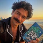 Luke Arnold Instagram - Up at sunrise to read books on the beach in my pjs. If you haven’t jumped over to my Tiktok yet, what are you doing? The First Page Pajama Party has hit the road 📚 (Outfit courtesy of @midnightmischiefsleepwear)