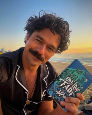 Luke Arnold Instagram - Up at sunrise to read books on the beach in my pjs. If you haven’t jumped over to my Tiktok yet, what are you doing? The First Page Pajama Party has hit the road 📚

(Outfit courtesy of @midnightmischiefsleepwear)