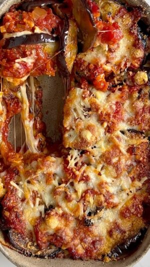 Miri Pérez-Cabrero Instagram - Parmiggina ❤️✨✨✨
.
I N G R E D I E N T E S:
⚡️2 berenejenas
⚡️1 cebolla
⚡️1 bote de tomate pelado
⚡️aceite oliva, sal & pimienta
⚡️hierbas aromáticas, orégano & albahaca
⚡️queso mozzarella & parmesano
.

I N S T R U C C I O N E S:
1️⃣ cortamos la berenjena y la llevamos al horno con un poquito de aceite y sal a 180° unos 40mins
2️⃣ en una sartén doramos 2 dientes de ajo con un poco de aceite y añadimos la cebolla. Añadimos un poco de agua y cuando el agua evapore añadimos las especias, un poco más de aceite y el tomate.
3️⃣ dejamos que se haga la salsa durante media horita a
fuego lento.
4️⃣ en una fuente apta para horno hacemos capitas de berenjena (ya estará hecha) + salsa tomate + queso mozarella y en la última capa añadimos el parmesano. Horno 180° 10 minutos más v listo!!! A disfrutar!💘💘💘💘 te gusta???? 
.
#mirisrecipes #healthy #saludable #recetassanas #recetas
#receta #recetasfaciles #recetassaludables #recetafit