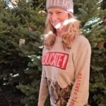 Mo Collins Instagram – Favorite day of the year!! Christmas Tree day!!!!! I love them!! Walter gave a sniff. Beanie has already nearly crashed the tree to the ground after tangling herself in the lights. 😂😂 Sweater from @standupforpitsfoundation  Go get one!! Also have my #pittiemom cap #christmastree #bluenoblefir #holiday #Christmas