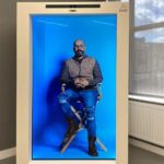 Nima Akbarpour Instagram - ARHT Capcule در ظاهر به نظر میاد که توی یک جعبه نشستم اما واقعیت اینه که اون تصویر هولوگرافیک منه که داره اون تو پخش می‌شه و من توی اون جعبه، حضور فیزیکی ندارم هر چند چون همه حرکات و تصویر و صدا زنده هستند و سطح چشم هم با چشم مخاطب هماهنگه، نتیجه‌اش طوریه که انگار واقعا اون تو هستم و حرف می‌زنم. یک حضور باورپذیر. #holographic #technology London, Unιted Kingdom