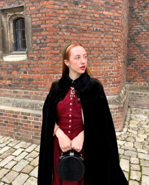 Rebecca Flint Instagram - if you can’t wear a cape in hampton court palace i’m not sure where you can 🌹?

I have always wanted to see this incredible tudor palace for myself and I was so excited to have the chance!

they had live cooking demonstrations inside the original kitchens, and we saw so many amazing tapestries and paintings… incredible day to visit!

the puff headband trend always reminds me of the French Hood so I had to wear this army green one, along with this spectacular velvet and silk cape picked up from @classiccarbootsale in the spring! My dress is vintage from Japan, and my bag is @aspinaloflondon. The shoes are @empressaustralia 🔍

Not forgetting my B necklace as an homage to Anne 🅱️❤️