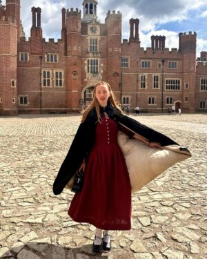 Rebecca Flint Instagram - if you can’t wear a cape in hampton court palace i’m not sure where you can 🌹?

I have always wanted to see this incredible tudor palace for myself and I was so excited to have the chance!

they had live cooking demonstrations inside the original kitchens, and we saw so many amazing tapestries and paintings… incredible day to visit!

the puff headband trend always reminds me of the French Hood so I had to wear this army green one, along with this spectacular velvet and silk cape picked up from @classiccarbootsale in the spring! My dress is vintage from Japan, and my bag is @aspinaloflondon. The shoes are @empressaustralia 🔍

Not forgetting my B necklace as an homage to Anne 🅱️❤️