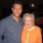 Robert Gant Instagram - I’m sad to hear of the passing of @bettymwhite today. What a wonderful life fully lived. So many people touched and impacted. When I had the good fortune to work with her on “Hot in Cleveland,” we did what’s called a speed through in the makeup room on taping day. A speed through is essentially the process of whipping through the lines of an entire episode to refresh them quickly before going live in front of an audience. Because it was only the third episode, everyone was especially energized as the show was still finding its feet. Betty’s “date” for the episode was none other than the amazing Carl Reiner, who passed away last year. As we all sat in a circle zipping through our lines, one of my fellow guest stars leaned over and, referring to Betty and Carl, whispered, “Can you believe we’re sitting here doing a speed through with two of the progenitors of comedy?” For indeed we were. And indeed they were. When we were about to start shooting, Betty came in and found a chair next to me just off the set where we were both to be making our entrances. She sighed a big sigh as she sat, and I said, “How are you doing?” She didn’t miss a beat and asked, “Is it time to go home yet?” I laughed, and we chatted for a bit. I’ll never forget the experience. I guess now it really was time to go home. Rest well, Betty. CBS Studios-Radford