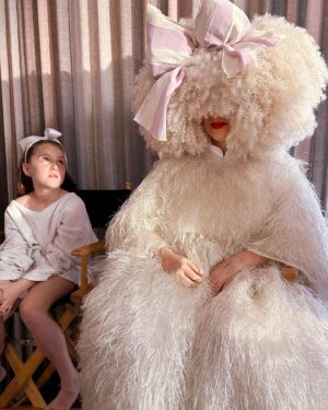 Sia Instagram - Waiting patiently ❣️ #GimmeLove - Team Sia

[image description: a girl with a bow sitting next to Sia in a big white dress and white wig]