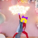 Sia Instagram - Gimme love, gimme love, gimme love, baby 💖💖💖 - Team Sia [image description: Sia dances below balloons and a sign that says 'GIMME LOVE']