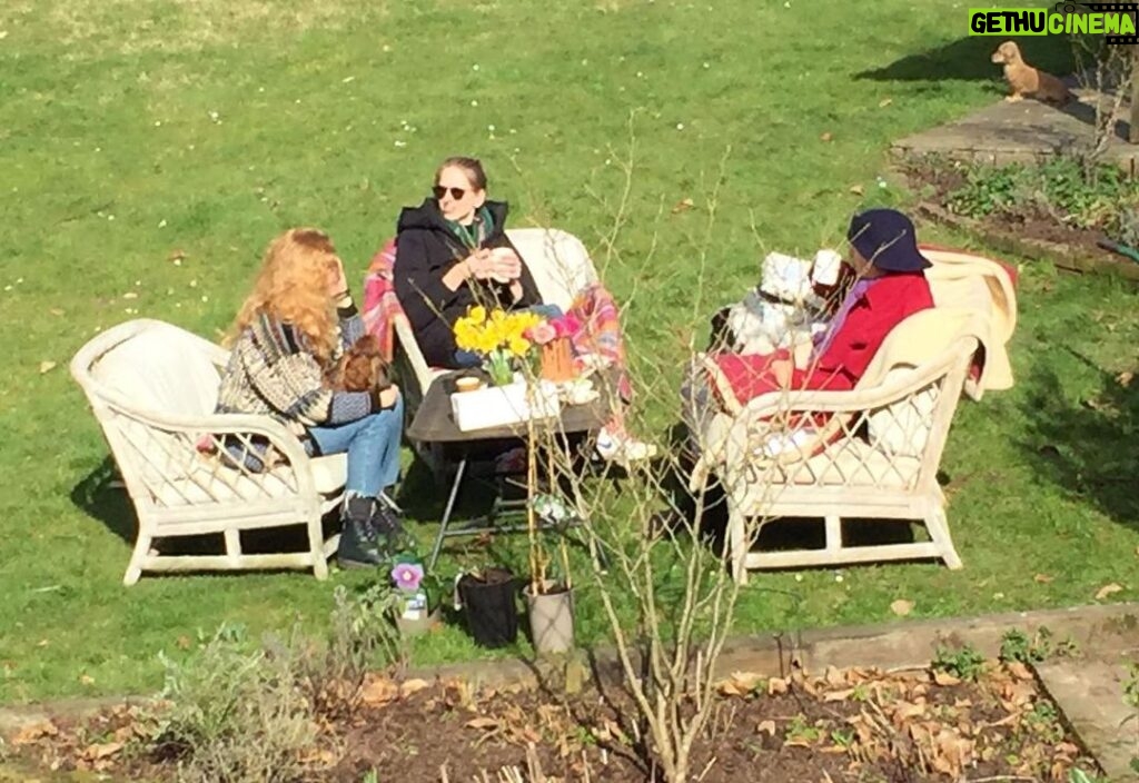 Tamzin Merchant Instagram - A birthday tea in the sunshine for mum 💖 (photo taken from the upstairs window by dad who is isolating with covid but now thankfully on the mend) Featuring the birthday girl @suzy.merchant in her red coat and @katemerchant looking veh cool in the middle 💖🌸
