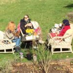 Tamzin Merchant Instagram - A birthday tea in the sunshine for mum 💖 (photo taken from the upstairs window by dad who is isolating with covid but now thankfully on the mend) Featuring the birthday girl @suzy.merchant in her red coat and @katemerchant looking veh cool in the middle 💖🌸