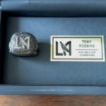 Tony Robbins Instagram – Ring Ring! 💎💍 ⚽ 🏆and @LAFC made history when the team won its first-ever MLS Cup in 2022 we’ve now got our CHAMPIONSHIP RING in hand!

This incredible milestone also marks my 7th championship ring across sports leagues. I’ve had the privilege to work with campus from MLS, NBA, MLB, NHL, and even E-Sports.  From founding the club back in 2014, crafting our colors and badge, engaging with the L.A. community and supporters, to our inaugural 2018 season in the brand-spankin-new Banc of California #soccer stadium, and ultimately claiming the 2022 MLS Cup Champions title—it’s been an INCREDIBLE 8-year ride. 🚀 

We’ve gone from a dream to a UNIFYING FORCE OF ENERGY and CHAMPIONSHIP TEAM for all Angelenos, right here in my original hometown. 🌴🌇🙌 
There are many people to congratulate and thank, starting with my dear friend and co-owner, PETER GUBER, for being an essential part of this incredible journey.❤️

A special shoutout to our coach, @stevecherundolo, for his EXCEPTIONAL LEADERSHIP and of course the players on the pitch! @carlosv11_, @jmacdaddy77, @garethbale11, and the entire team for their OUTSTANDING performance.

They showcased their collective hunger for VICTORY, netting a goal in the 128th minute against Philly and ultimately securing the CHAMPIONSHIP in a penalty shootout.

This Final will go down as one of the most LEGENDARY matches in all of MLS HISTORY.🔥
 This is a club that constantly finds a way, never backs down, and pushes through with RELENTLESS FOCUS—a true club of CHAMPIONS!  After last night’s commanding performance, LAFC advances to the Concacaf Champions League semifinals. Can you feel the MOMENTUM?! Perfect timing heading into their next match — El Traffico!! LAFC vs. cross-town riaval @lagalaxy on Sunday, April 16.

It’s such an honor to be a partner and owner in this exciting organization. 
While the victory is theirs, I’m deeply grateful to have been involved in this phenomenal experience. 😎  L.A. is BLACK and GOLD! 🖤💛⚽️