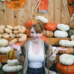 Bryce Dallas Howard Instagram – Hey, October 😉🍂⁣⁣
⁣⁣
📸: @andiejjane⁣⁣
⁣⁣
[ID: BDH playfully poses in front of a display at @traderjoes with pumpkins of all different shapes, sizes, and colors. In full autumn vibes, she wears navy blue jeans, a white t-shirt, and a beige and brown cardigan. 3 smiling scarecrows hang on the wall in the back.]⁣