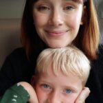 Bryce Dallas Howard Instagram - This baby boy turns 16 today and I LOVE HIM SO MUCH! Happy Birthday Theo!!!! Mumsie and Whoopsie love you ❤️⁣ ⁣ [ID 1: At the kitchen table, young Theo sits in BDH’s lap. They both smile softly as BDH gently rests her head on top of Theo’s.]⁣ ⁣ [ID 2: Sitting on the floor in comfy pajamas, BDH cradles a young Theo in her arms. BDH wears a fluffy light purple robe and Theo wears matching striped shirt and bottoms.]