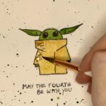Bryce Dallas Howard Instagram - #MayTheFourthBeWithYou 💫💚 Swipe to see the making-of 👉🏻 ⁣⁣ ⁣⁣ #TheMandalorian #BabyYoda #StarWars ⁣⁣ ⁣⁣ [ID: Showing off her new Grogu watercolor painting, BDH makes a kiss face]