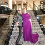 Bryce Dallas Howard Instagram - Joyful Moments with @jeffgoldblum: the B-side #JurassicWorldDominion ⁣ ⁣ [ID: Candid photos of Jeff and BDH playfully posing on the steps of a grand staircase. Jeff wears an all black leather ensemble and BDH wears a plum floor-length gown.]