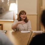 Bryce Dallas Howard Instagram - It’s #WorldTeacherDay and I can’t go without thanking the teachers/ mentors in my life who absolutely shaped who I am today and thanking the NYU students who made me a teacher in the first place 🥹 #NineMusesLab @ninemusesentertainment ⁣ ⁣ [ID: Around a big wooden table in an open classroom with twinkly lights, BDH teaches her “Making It & Mastery” course to the first cohort of NYU students in 2018]